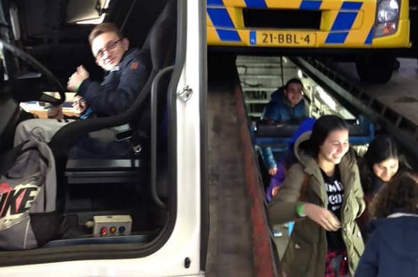 Leerlingen in en onder een vrachtwagen